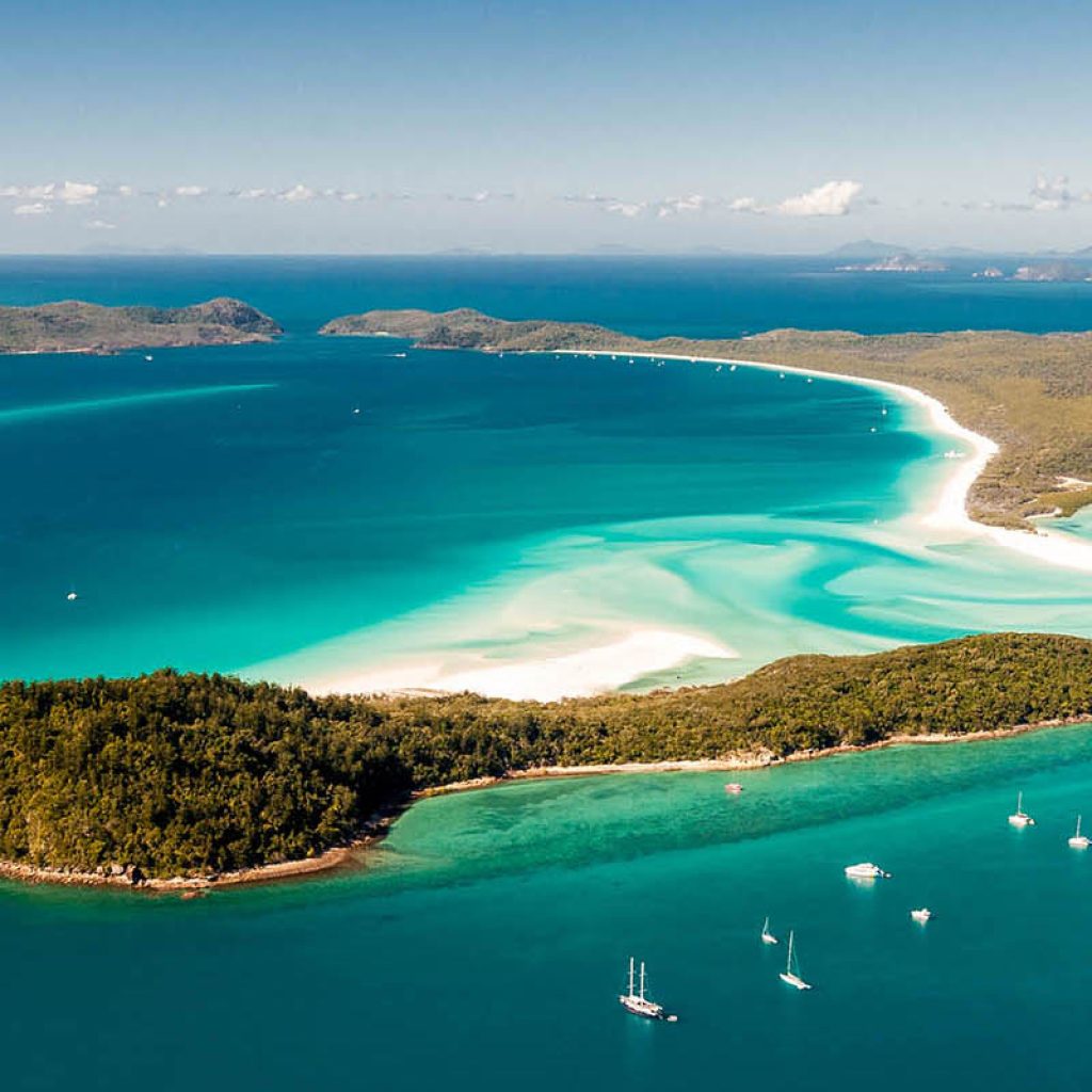 Hill Inlet from the air over Whitsunday Island - swirling white sands, sail boats and blue green water make spectacular patterns